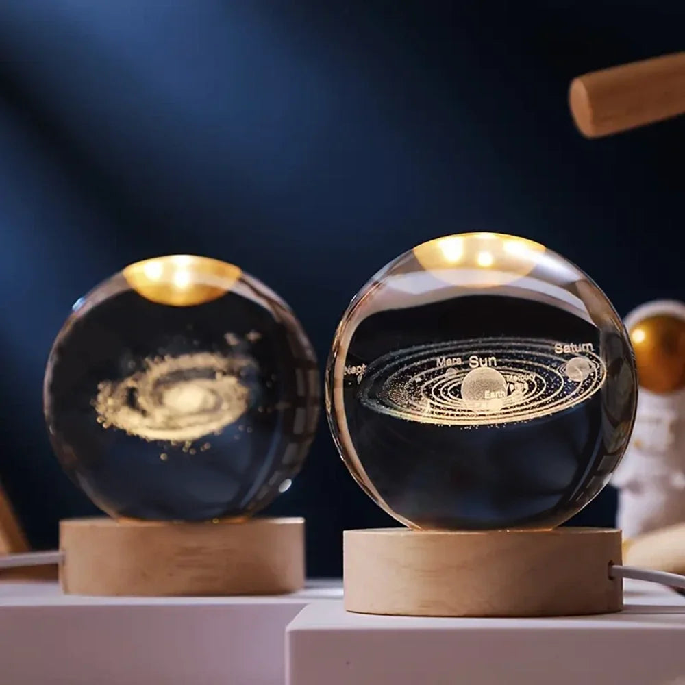 Luminous crystal ball with 3D engraved planets and space scenes, warm white LED glow