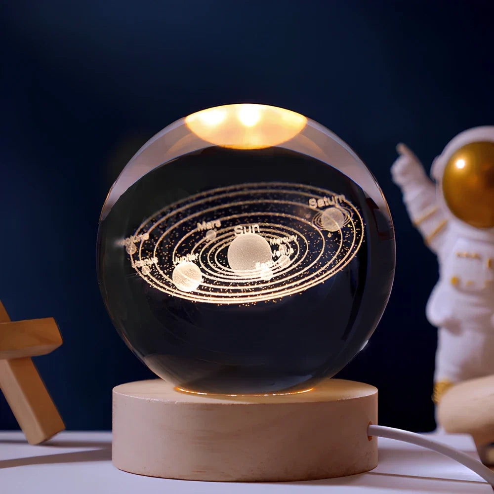 Luminous crystal ball with 3D engraved planets and space scenes, warm white LED glow 3