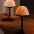 Hand-carved porcelain WhisperDome candle holder with walnut wood base, featuring nature relief design and warm candlelig