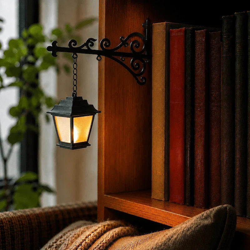 Ornate wrought-iron bookshelf light with illuminated pendant design between books 4
