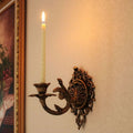 Ornate cast iron wall-mounted candle sconce with vintage scrollwork design