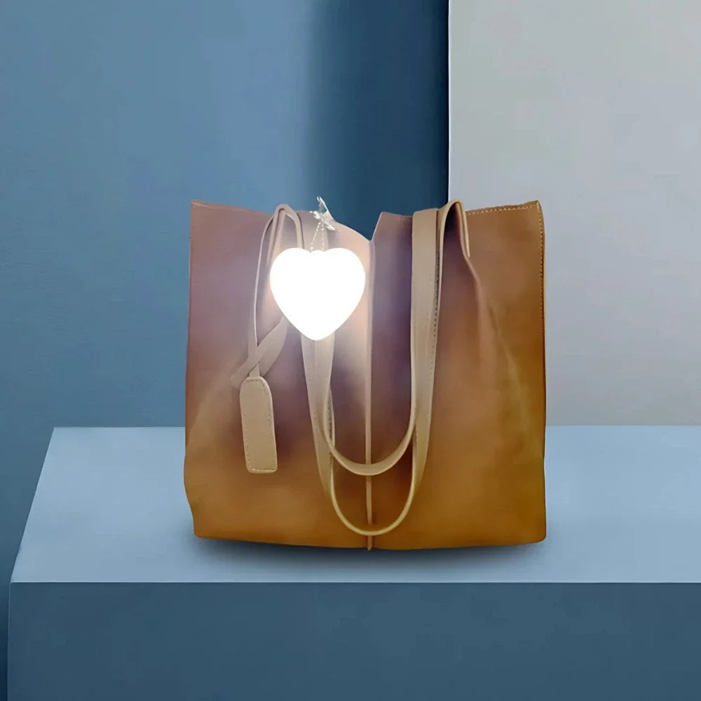 Compact touch-activated purse light illuminating a dark handbag interior. 9