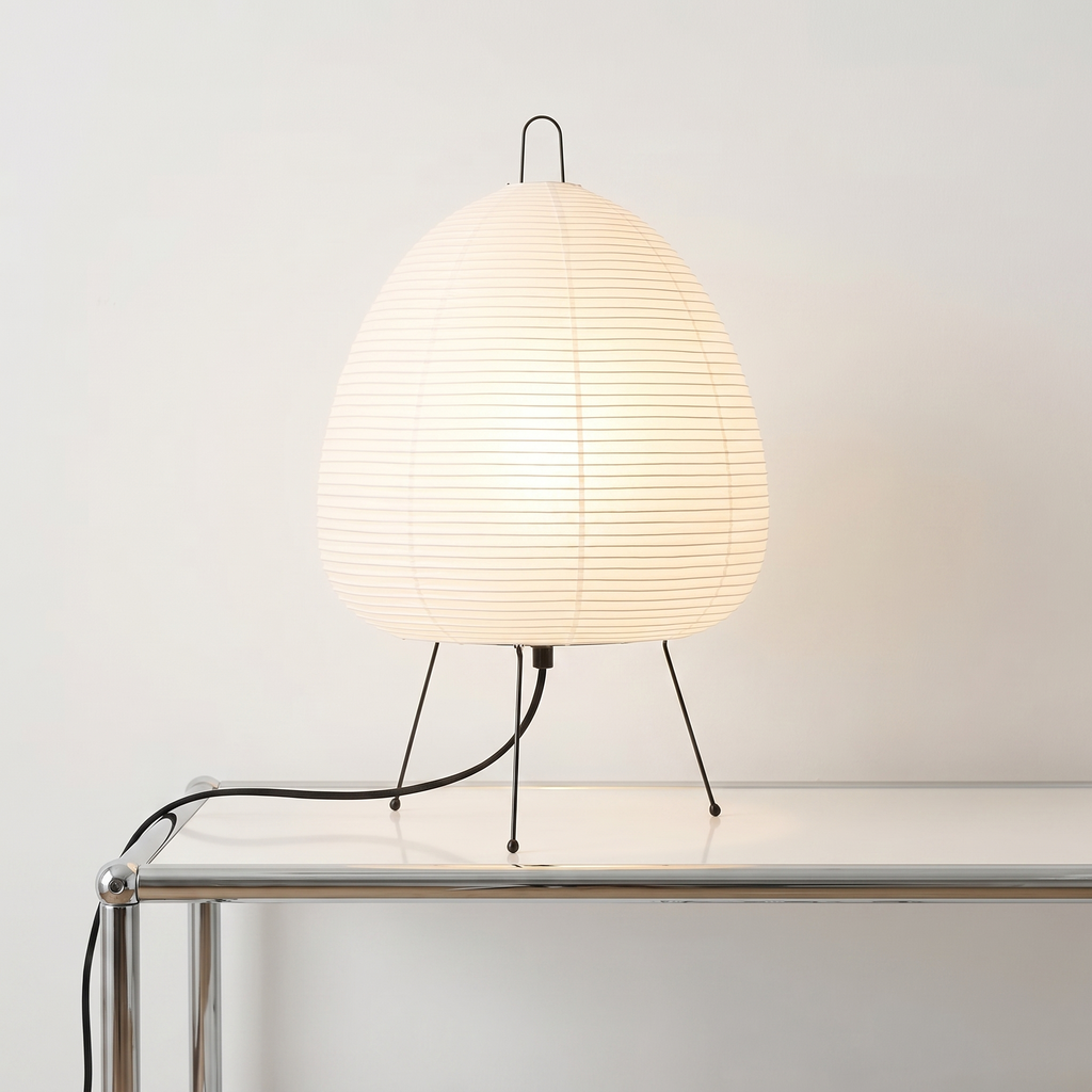 Sculptural Akari style paper table lamp casting a soft warm ambient glow in a modern room