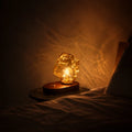 Sculptural amber glass table lamp with warm glow and natural oak base