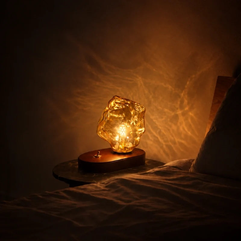 Sculptural amber glass table lamp with warm glow and natural oak base