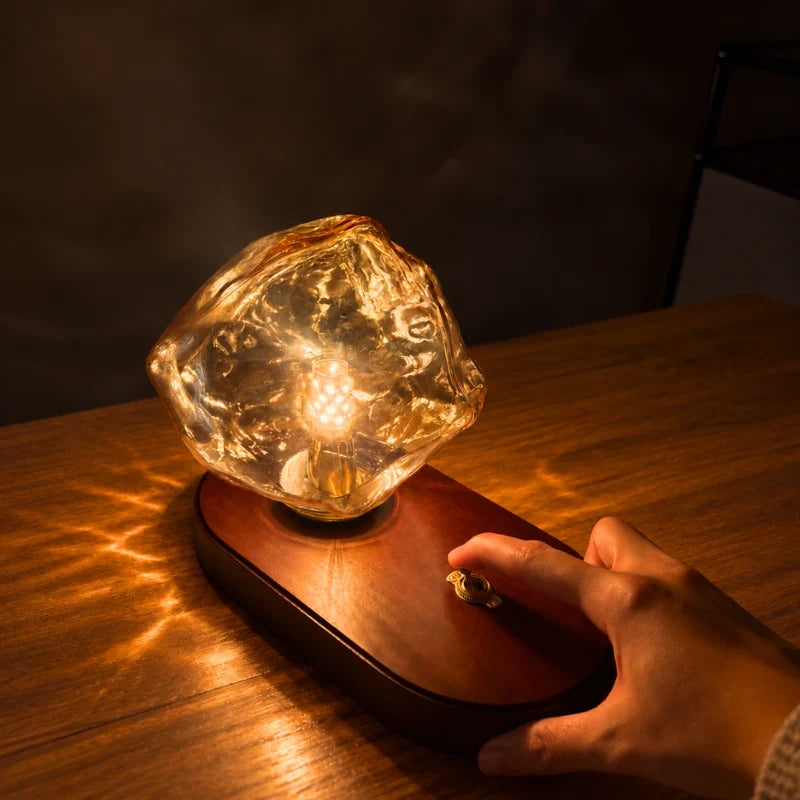 Sculptural amber glass table lamp with warm glow and natural oak base 4