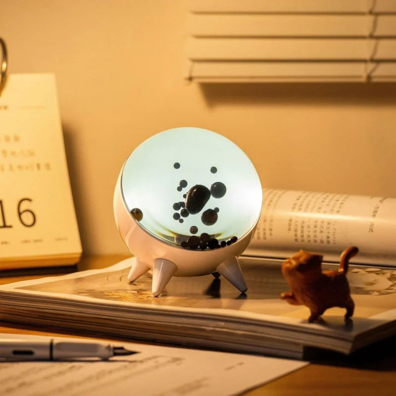 Sound-reactive ferrofluid display in clear glass sphere with black liquid pulsing to music rhythm