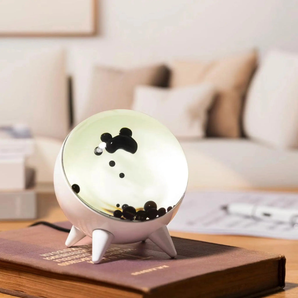 Sound-reactive ferrofluid display in clear glass sphere with black liquid pulsing to music rhythm 3